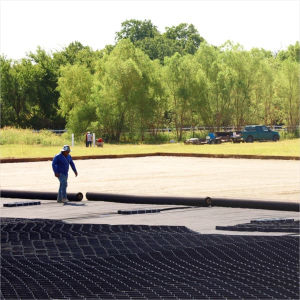 A man is standing in a Geotextile field.