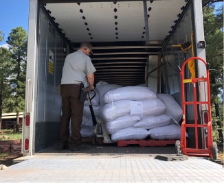 About: A man loading sacks into a truck.