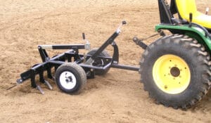 An Arena Rake with a plow attached to it.