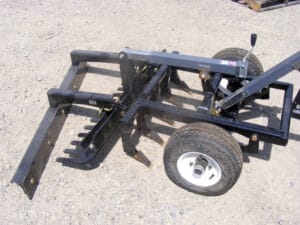 A tractor with an Arena Rake attached to it.