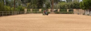 A man riding a horse on a dirt track.