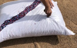 A person putting a pillow on the ground.