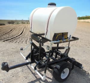 A water tank on a trailer in a field, equipped with Water Kits AR.