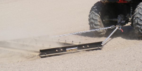 An atv using an Arena Drag to pull a chain through the sand.