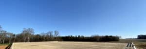 A Horse Ring with meticulously prepared Horse Arena Footing in the middle of a sprawling field.