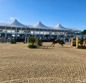 A horse is jumping over an obstacle at an equestrian event.