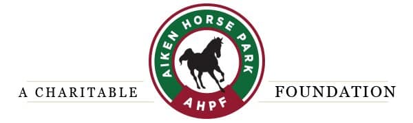 The logo for Aken Horse Park, a charitable AFP foundation, incorporates elements representing the equestrian world and horse arena footing.