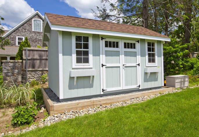 Blue and white shed in a backyard