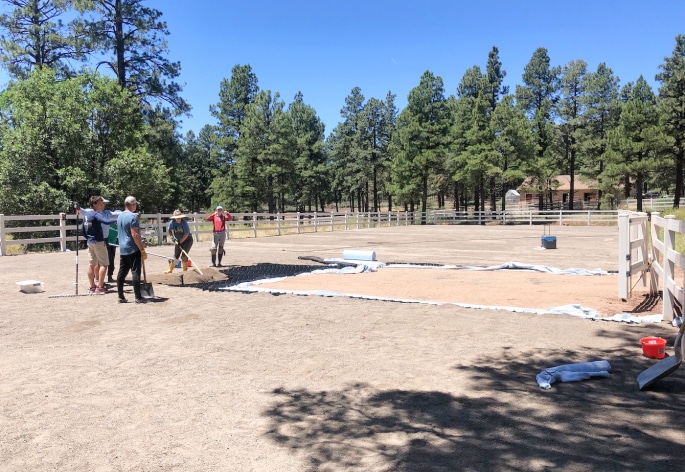 A group of people standing in a dirt field.