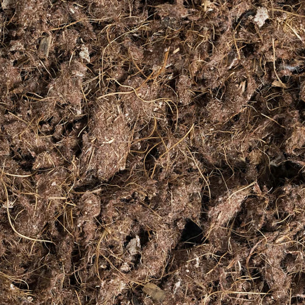 A close up of a pile of brown mulch, featuring Noviun Fiber and Elastomer Horse Footing.