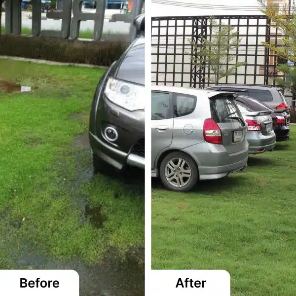 A car is parked in front of a grassy area.